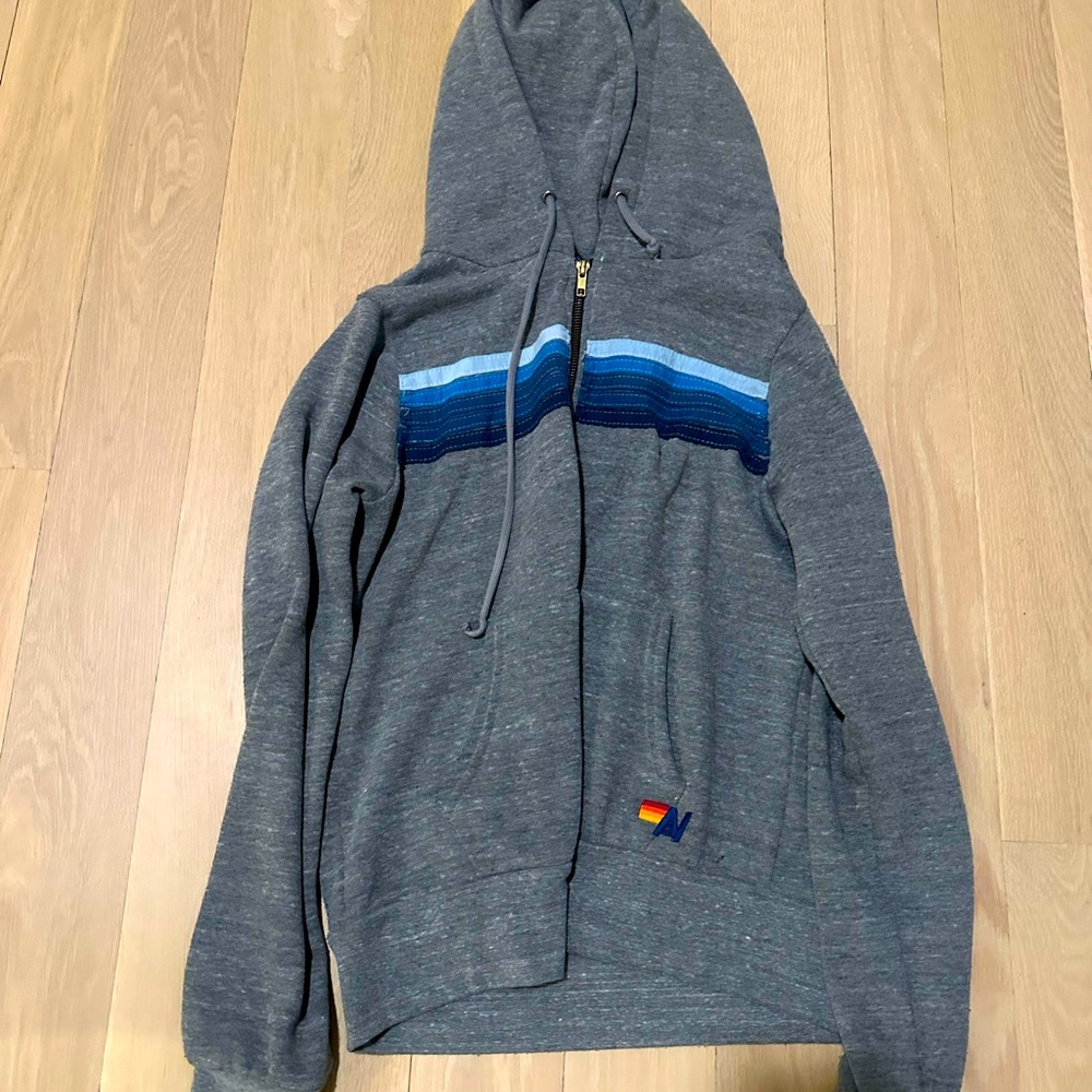 Gray aviator nation zip up with blue and white stripes across